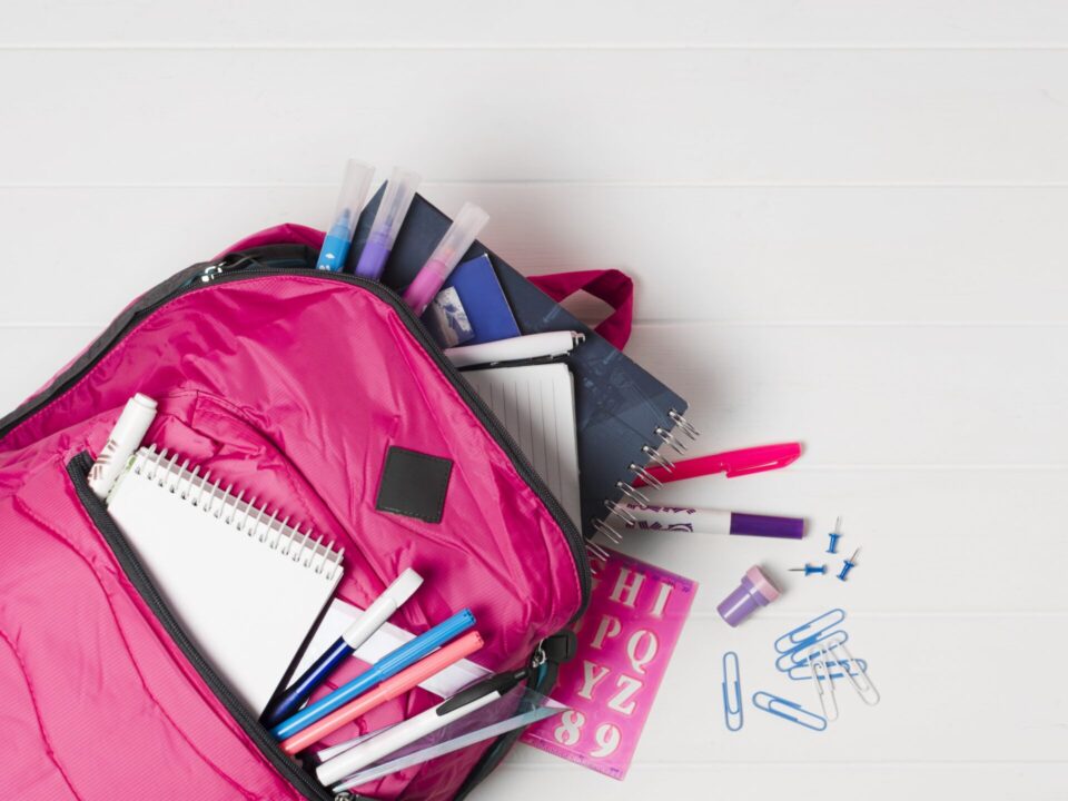 Mochila rosa con utiles escolares vista superior 1