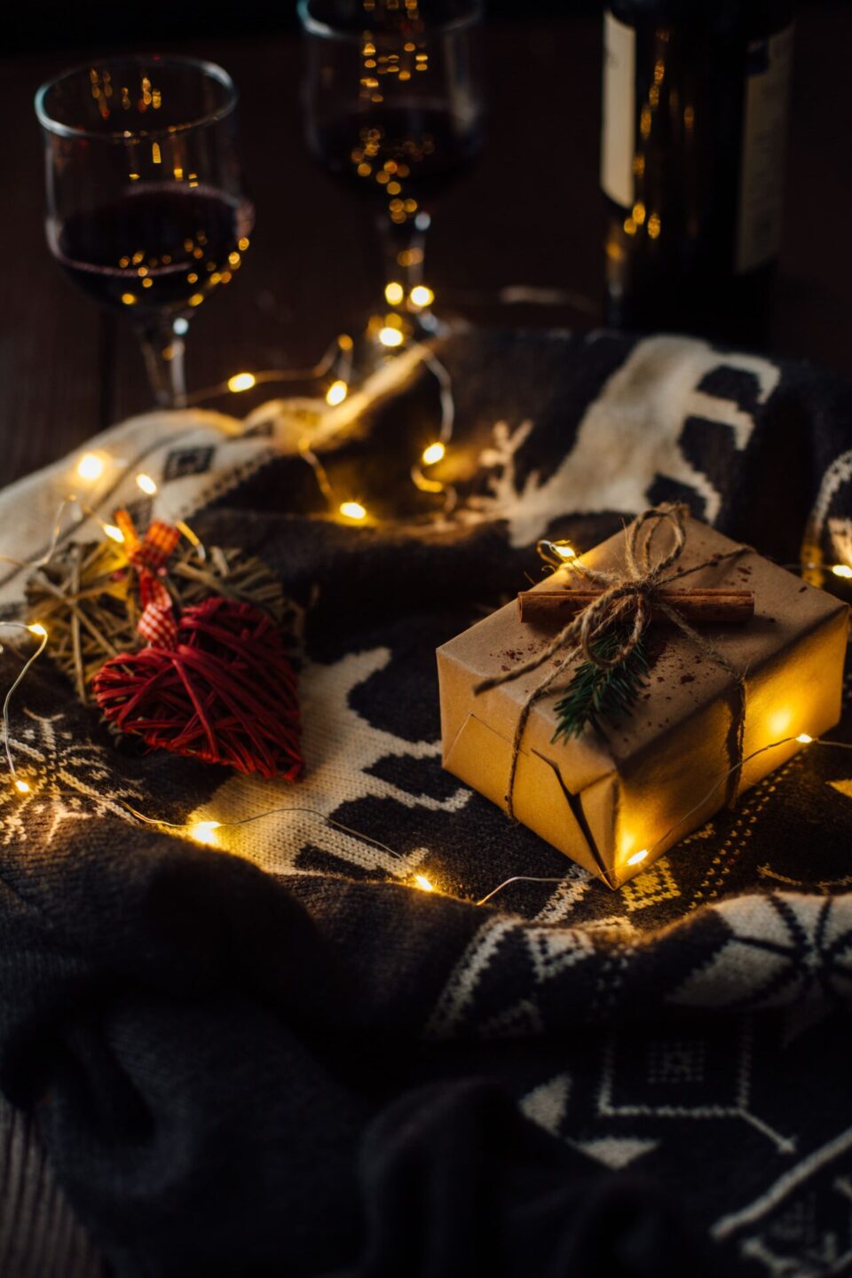 Regalo de navidad con sueter de punto luces de navidad y dos copas de vino 1